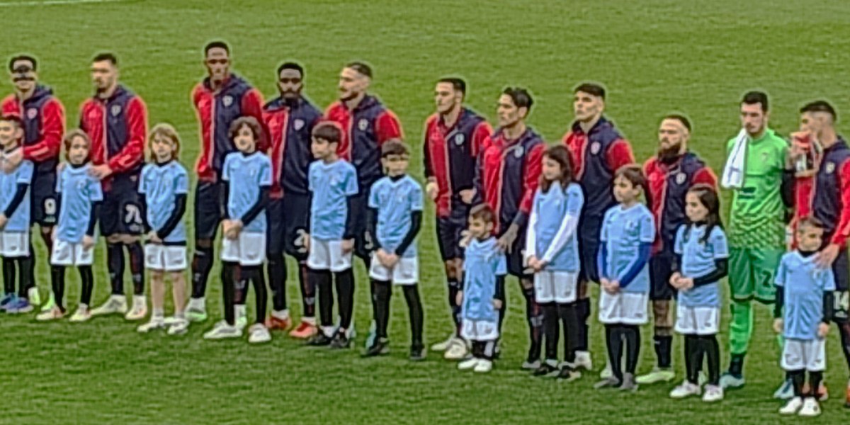 Sahada dizilen futbol takımı ve maskot çocuklar