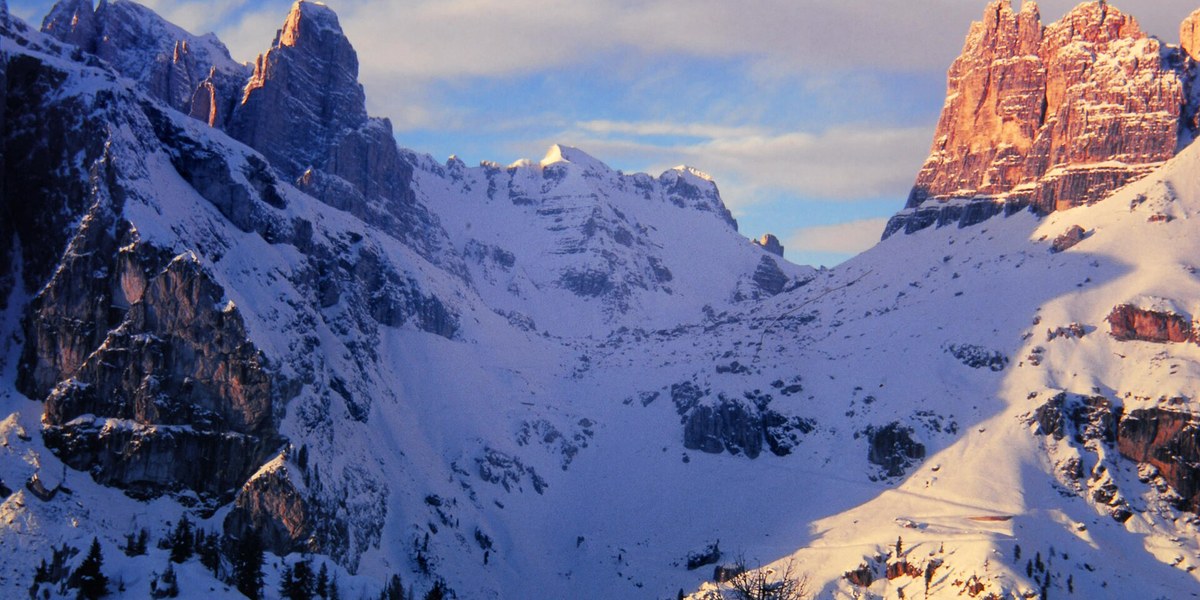 Cortina d'Ampezzo'da gün batımında karlı Dolomit zirveleri